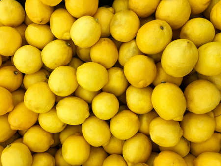 A lot of lemons on sale at farms market. Top view. Food background. Mobile photoの写真素材