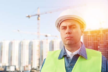 Worker staff or engineer in white protective helmet at construction site. Outdoorsの写真素材