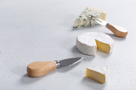 Different types of cheese served with fork and knife on white backgroundの写真素材