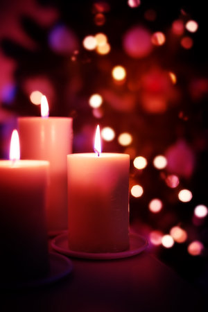 Christmas burning candles on garland lights blurred background, decorative New Year card with copy...