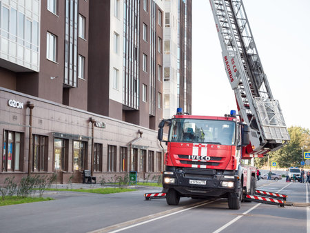 Saint-Petersburg, Russia - 23 September 2020: Firetruck and Firefighters near building ready to put...