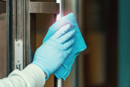 Cleaning and sanitizing door entrance from bacteria and virus. Infection prevention and control at public places during epidemic. Antiseptic, Hygiene and Healthcare concept, Covid-19 second wave.の写真素材