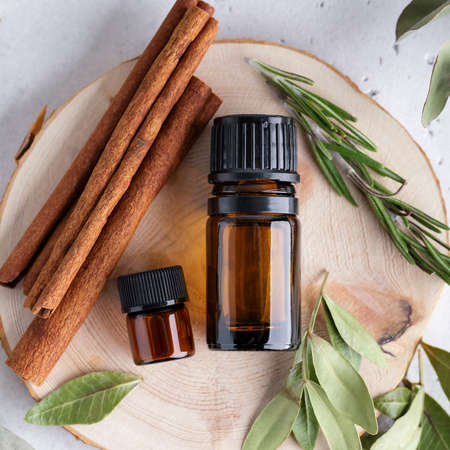 Natural ingredients for immunity boosting, aromatherapy with essential oils of rosemary, cinnamon and eucalyptus plants. Herbs and amber bottles top view.の写真素材