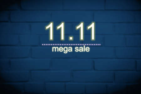 Dark blue brick wall background with neon electric inscription date 11.11 - Single Day and Shopping Season Concept.の写真素材