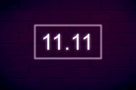 Dark brick wall background with neon electric inscription date 11.11 - Single Day and Shopping Season Concept.の写真素材