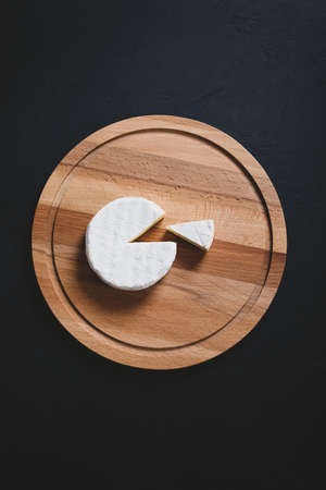 Sliced camembert on cheese platter on dark background. Top viewの写真素材
