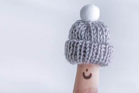 Fingers in knitted warm small hats, winter season concept