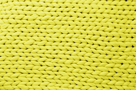 Trendy color 2021. Yellow illuminating color texture background from merino knitted blanket, copy...