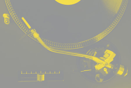 Turntable with vinyl record and stylus, closeup top view. Yellow and gray tone