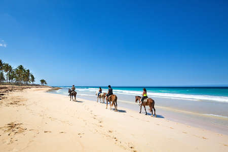 DOMINICAN REPUBLIC, PUNTA CANA - 20 MARCH 2019: People riding horses on Macao beach. Famous excursion for touristsのeditorial素材