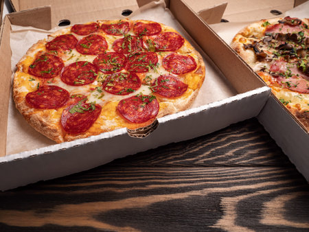 Set of italian pizza in cardboard boxes on wooden background, closeupの写真素材