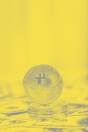 Bitcoins on dollar banknotes background, closeup. Trendy colors of 2021 - Ultimate Gray and...