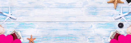 Honeymoon in tropical paradise. Travel objects on blue wooden background. Long bannerの写真素材