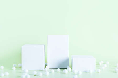 White empty stands on light green color background. Blank podiums shopfront decorated bubbles. Showcase for cosmetic or beauty promotions. Product display advertisement. Copy space.の写真素材