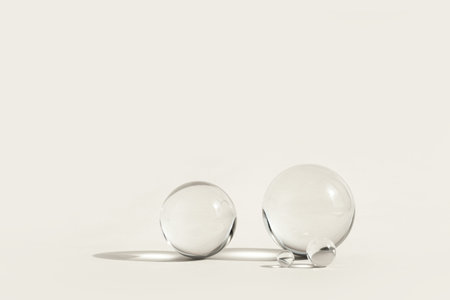 Astract backdrop with glass spheres on pastel color background with sun reflections, monochrome