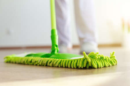 Home, housekeeping concept. Household equipment - cleaning wooden floor with mop, closeup, indoorsの写真素材