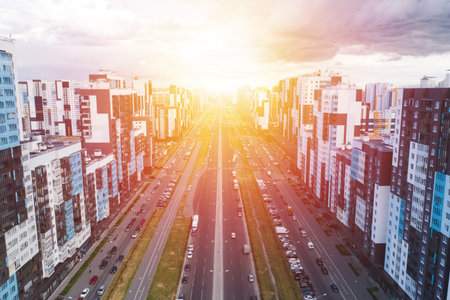 Street with houses and road. Komendantsky Prospekt aerial view from drone. Sunset time
