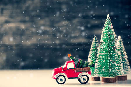 Christmas Car carrying fir tree over wooden background with New Year spruce trees. Winter holidaysの写真素材