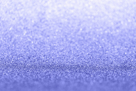 Magic glowing bokeh in trendy color of 2022 - Very peri. Abstract blurred glitter background.