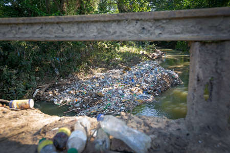 Pollution floating in tropical river, view from bridge. environmental problem concept.の写真素材