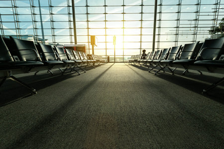 Empty airport terminal with seats in lounge hall in front of windows background, nobody