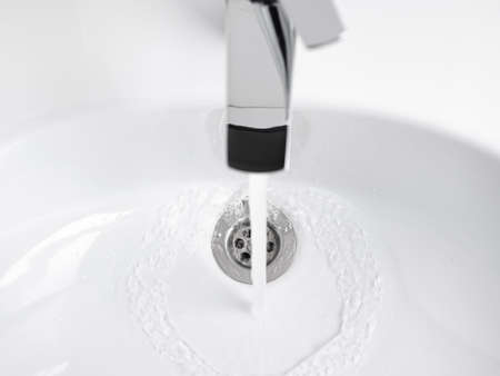 Water running from Faucet tap in white sink. Nobodyの写真素材