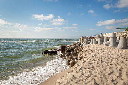 Yantarny public beach and sea view to the gray seascape, waves and big stone breakwaters blocks at pier, Kaliningrad regionの写真素材