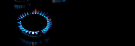 Kitchen gas burner flaming in the dark, closeup. long banner
