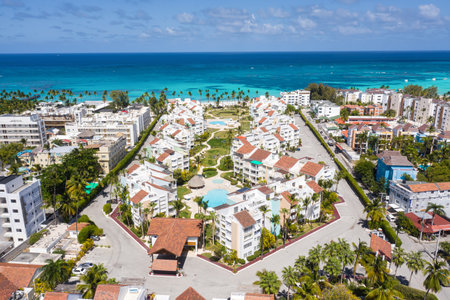 Caribbean beach of Atlantic ocean with luxury resort, coconut palm trees and azure water. Travel destination for holidays. Aerial view from droneの写真素材