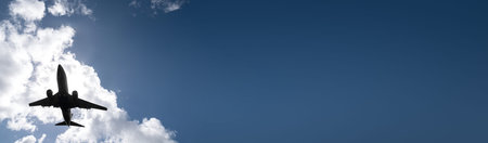 Airplane on sky and clouds background. Travel and transport concept. long banner