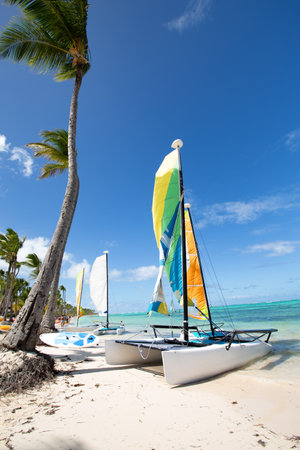 Bavaro beach in sunny day with calm Atlantic ocean and white sandy beach, focus on closeup boat, Dominican republicの写真素材