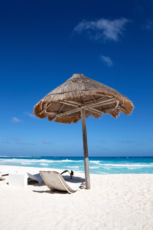 Sun umbrella ans sunbed on white sandy beach with turquoise ocean water. Caribbean sea travel destination. Bounty and pristine nature for vacation. Nobodyの写真素材