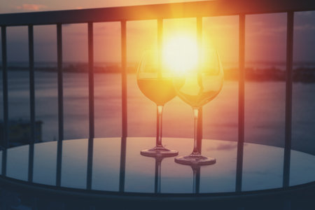 Two wineglasses with red wine with sun light through glasses on sunset. Nobodyの写真素材