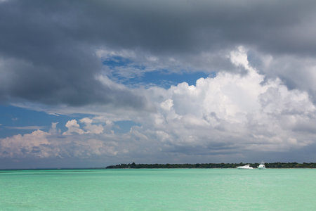 Turquoise Caribbean sea and blue sky with dark clouds before rain and thunder, amazing colors of tropical nature, natural pool of Caribbean sea, Dominican Republicの写真素材