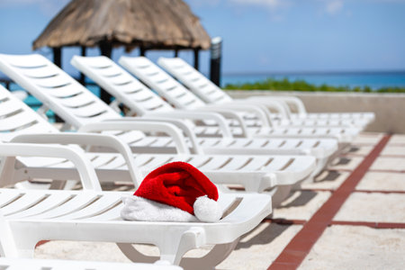 Santa Claus Hat on sunbed on caribbean sea background. Christmas and New Year vacation on tropical beachの写真素材