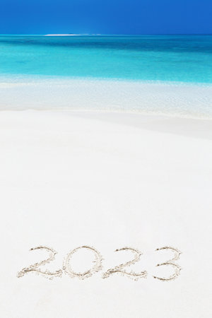 Handwriting inscription numbers 2023 on perfect tropical sandy beach, travel vacation and winter holidaysの写真素材