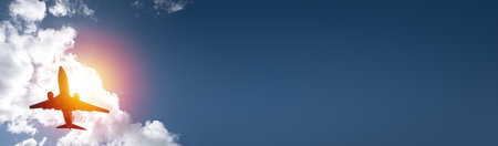 Airplane on sky and clouds background. Travel and transport concept. long bannerの写真素材