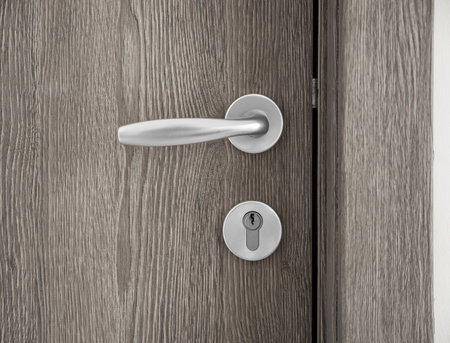 Detail of white door with chrome handle elements, part of apartment interior. close upの写真素材