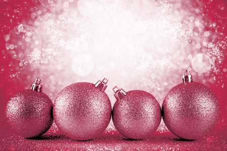 Pink Christmas baubles on silver glitter with defocused lights on background. Viva Magenta color of the year 2023の写真素材