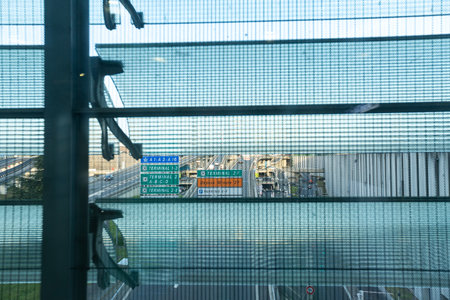 PARIS, FRANCE - April 11, 2022: Window view from airport Charles de gaulle outside on traffic road with street signs directionsのeditorial素材