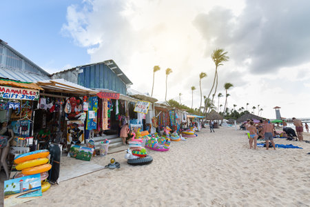 DOMINICAN REPUBLIC, BAYAHIBE - DECEMBER 16 2021: Well stocked shops on Dominicus beach selling swimming pool floats inflatables and gifts, tourists relaxing.のeditorial素材