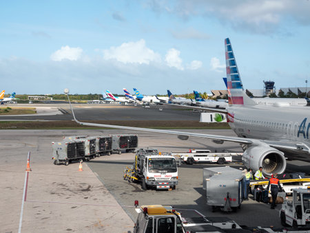 DOMINICAN REPUBLIC - 9 APRIL 2022: Airplane preparing for flight on airport runway. Unloading baggage from planeのeditorial素材