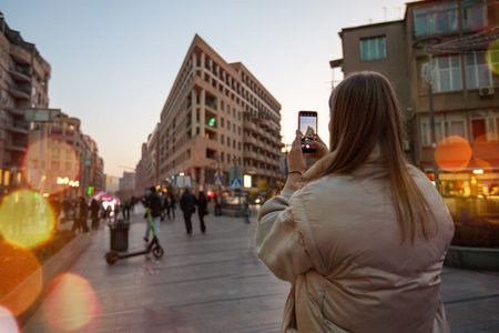 YEREVAN, ARMENIA - November 24th, 2022: Woman taking pictures by smartphone of a scenic urban...