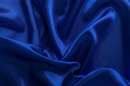 Blue atlas fabric material background, silk abstract textile surface, drapery clothの写真素材
