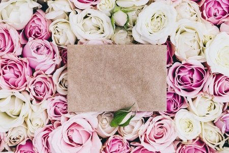 Empty craft paper invitation with copy space on roses background, greeting botanical card, mock-upの写真素材
