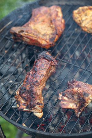 Cooking different meats on barbecue. Grilled and roasted lamb steaks on bbq. outdoorsの写真素材