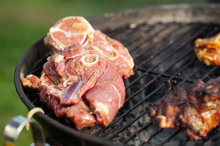 Cooking different meats on barbecue. Grilled and roasted lamb steaks on bbq. outdoorsの写真素材
