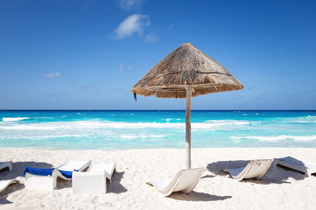 Caribbean sea coastline with grass sun umbrella and wooden beach beds. vacation conceptの写真素材