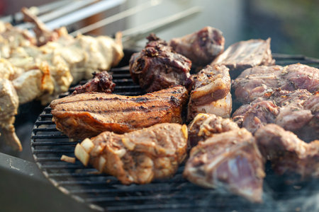 Cooking different meats on barbecue. Grilled and roasted lamb steaks on bbq. outdoorsの写真素材