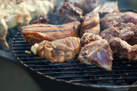Cooking different meats on barbecue. Grilled and roasted lamb steaks on bbq. outdoorsの写真素材